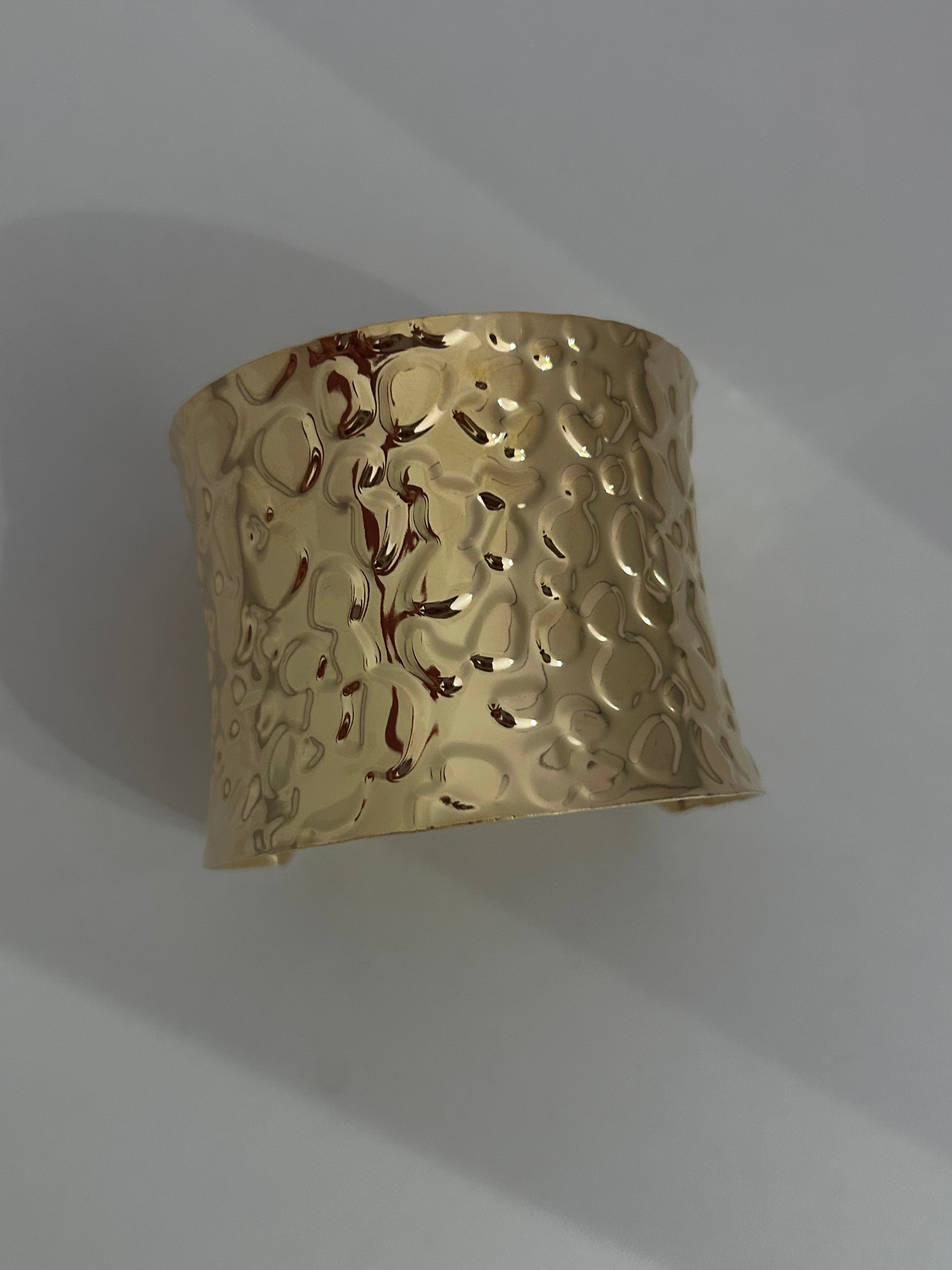 Bracciale rigido dal design elegante e deciso, realizzato in metallo color oro