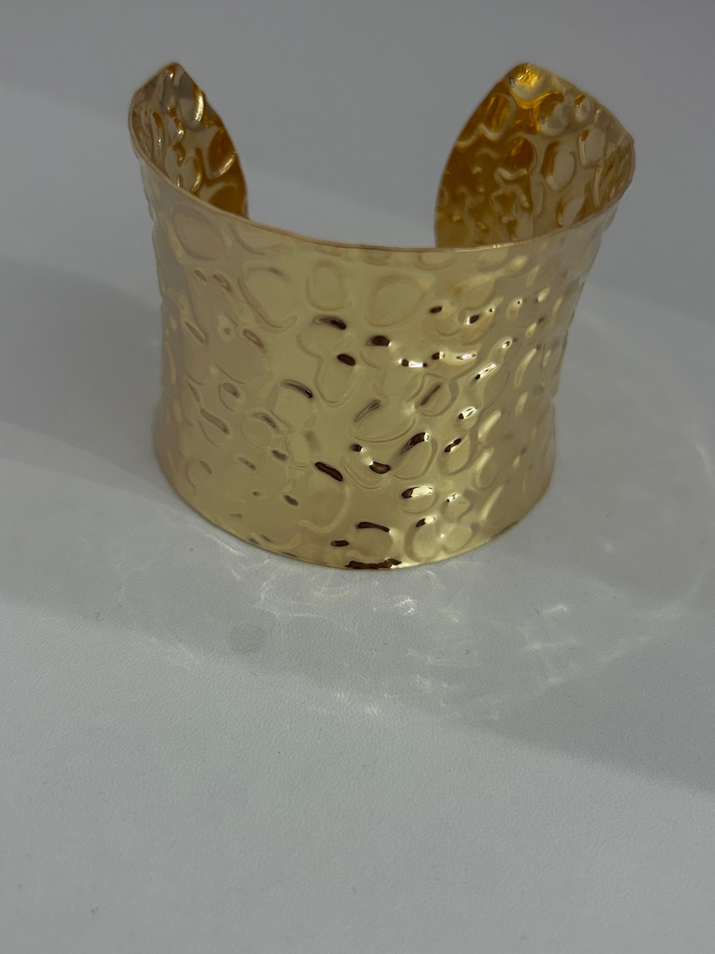 Bracciale rigido dal design elegante e deciso, realizzato in metallo color oro